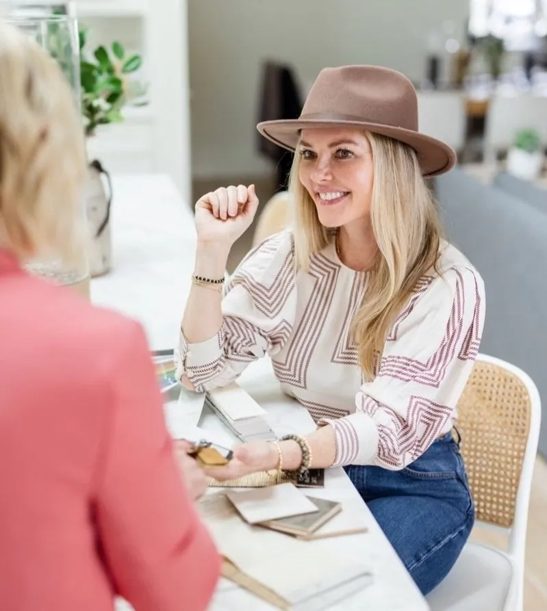 Meredith Gough sharing a relaxed moment with a client at a beautifully styled table.